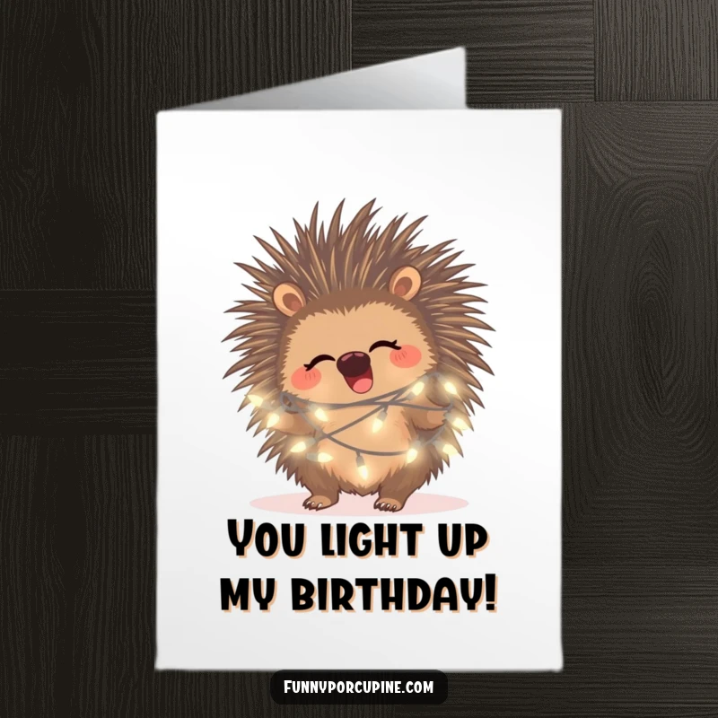 Free printable birthday card featuring a porcupine giggling happily while tangled in glowing fairy lights, radiating festive cheer.